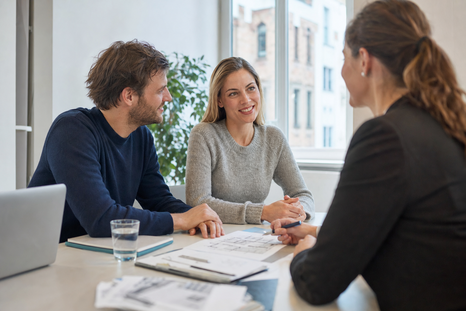 Beratungsgespräch eines Paares mit einem Finanzierungsexperten am Schreibtisch